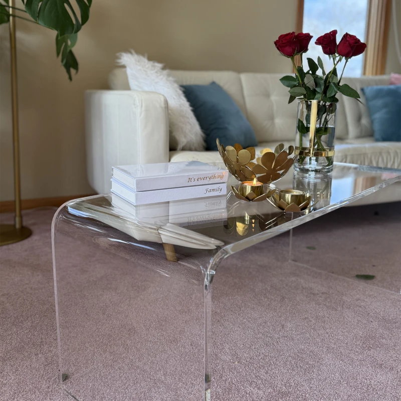 Transparent acrylic coffee table with golden decor items