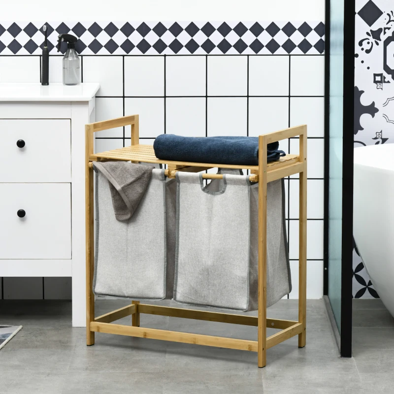 Bamboo laundry organizer with two fabric hampers and towel shelf.