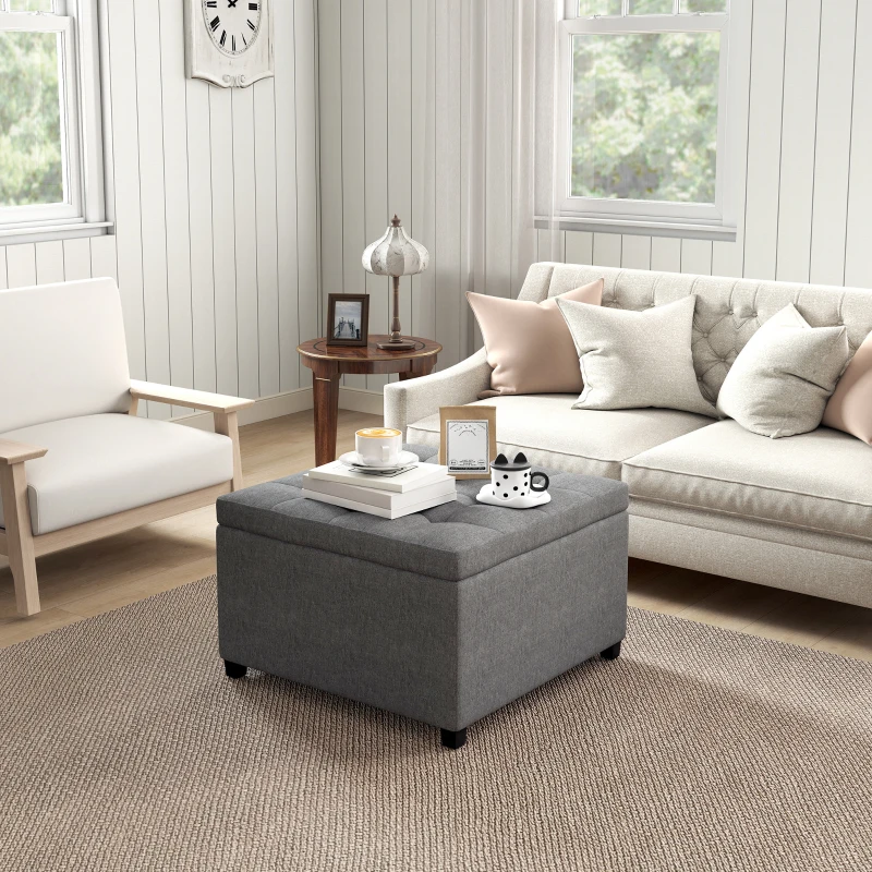 Gray fabric square tufted ottoman table with books and decor
