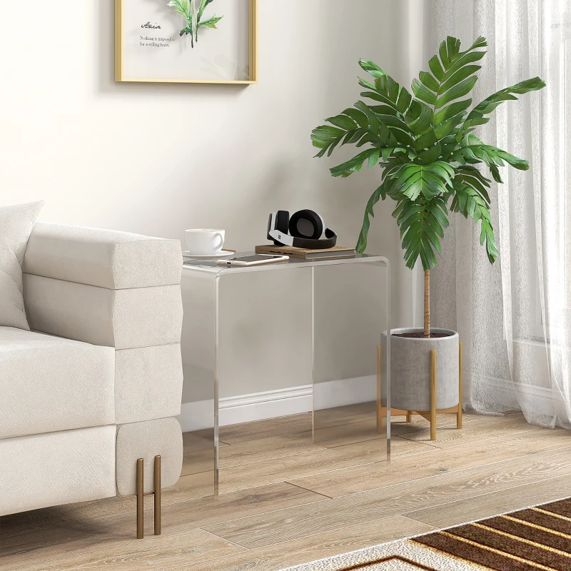 Clear acrylic end table beside couch with potted plant and coffee cup
