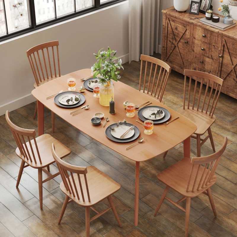 Natural wood rectangular dining table with matching chairs under warm light
