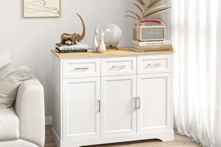 White modern sideboard with decorative art and books in bright living room.