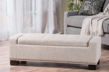Beige fabric storage ottoman in bright living room with sofa