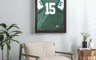 Framed sports jersey displayed on living room wall above chair
