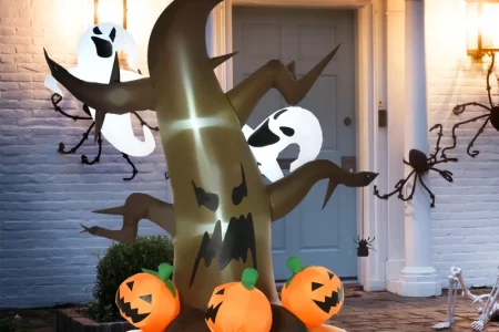 Inflatable Halloween tree with glowing pumpkins and ghosts outdoors.