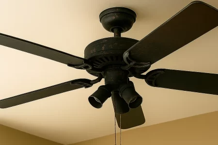Ceiling fan with dark rustic finish mounted on beige ceiling