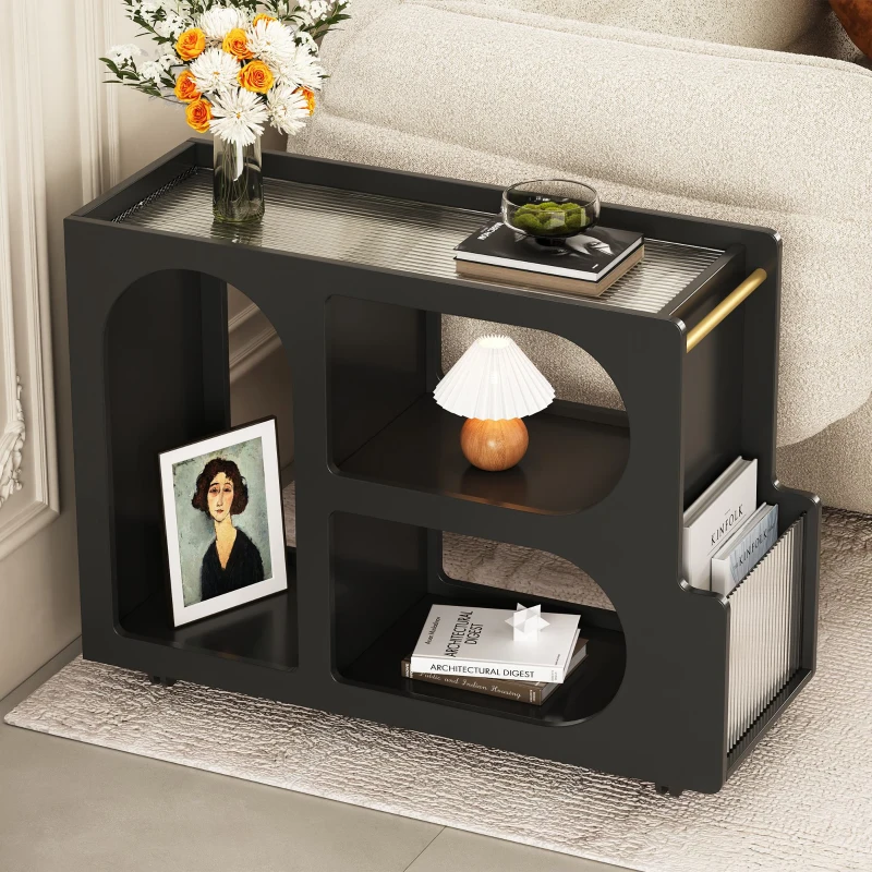 Stylish black end table with shelves, books, lamp, and flower vase beside sofa