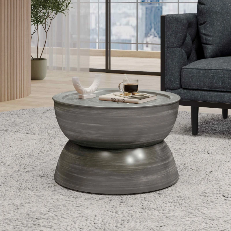 Grey hourglass-shaped round coffee table with glass top and modern décor.