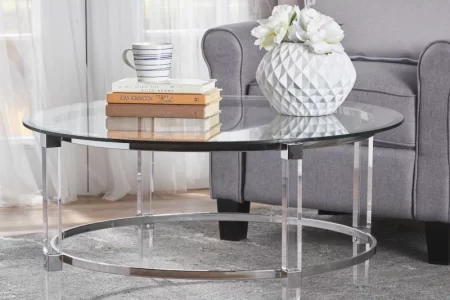 Glass round coffee table with books and vase in living room