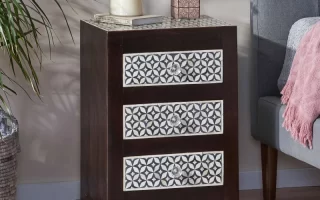 Dark wood 3-drawer nightstand with patterned front panels beside bed