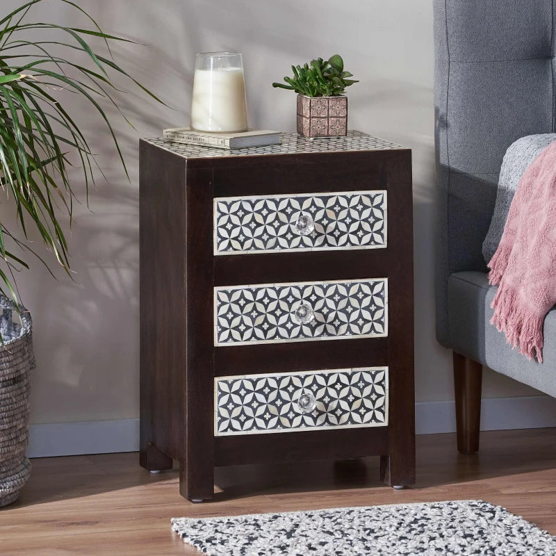 Dark wood 3-drawer nightstand with patterned front panels beside bed
