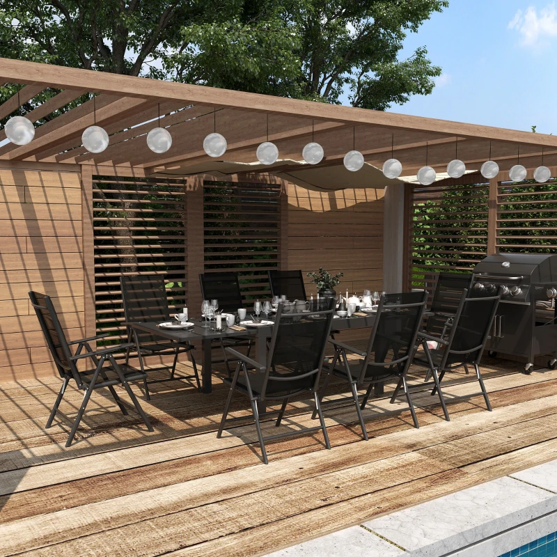 Outdoor black metal dining set under pergola with string lights.
