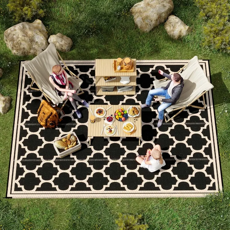 Family enjoying picnic on black-and-cream checkered outdoor rug in garden.