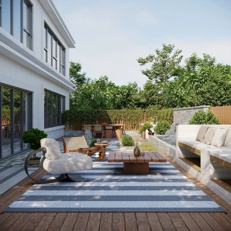 Modern backyard deck with striped gray-white rug and outdoor seating.