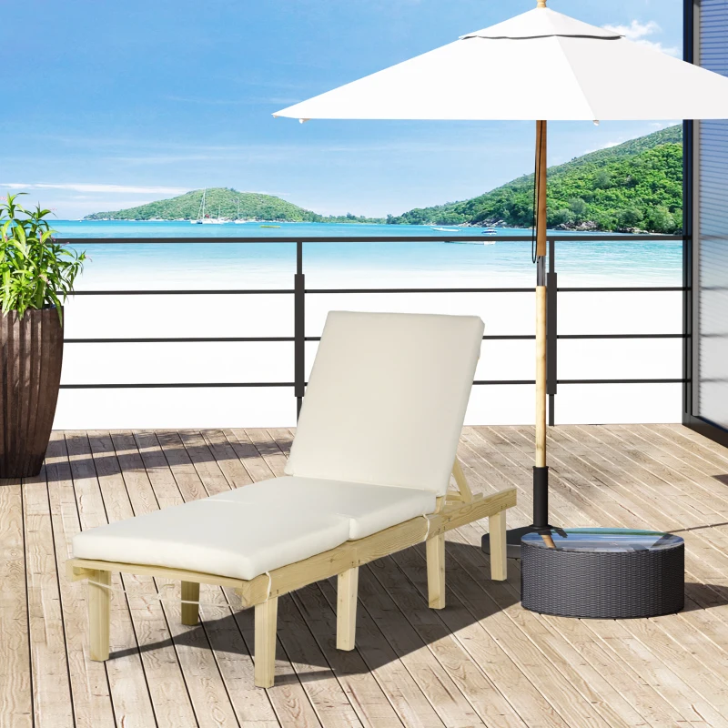 Beige cushioned wooden lounger under umbrella overlooking ocean view