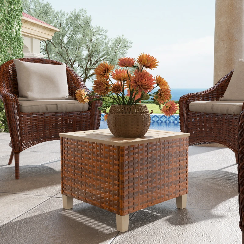 Wicker patio end table with flower vase between rattan chairs