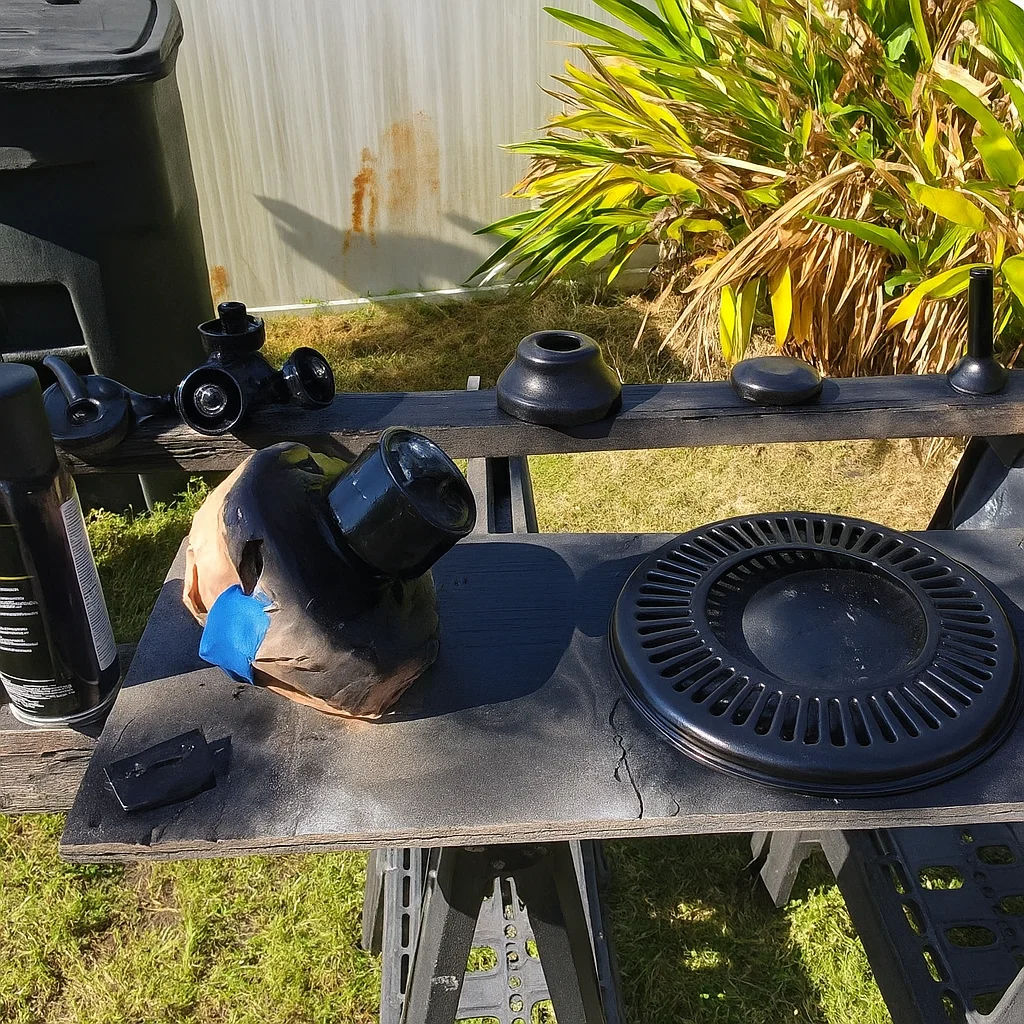 Ceiling fan motor housing and parts painted black drying outdoors