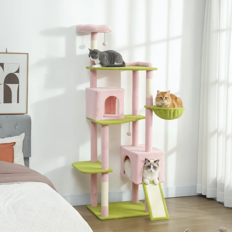 Multi-level pink and green cat tree with three cats playing.