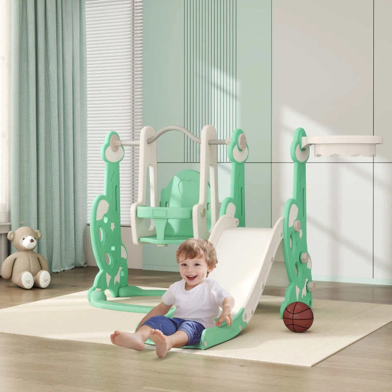 Happy toddler sliding on green indoor swing and slide set.