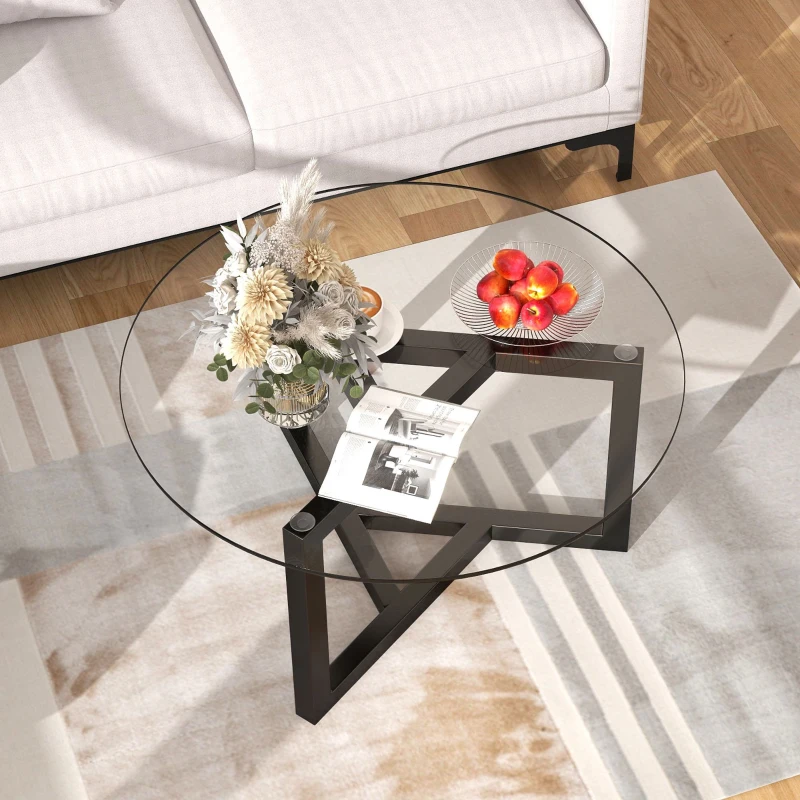 Round glass coffee table with dark wooden base and floral décor.