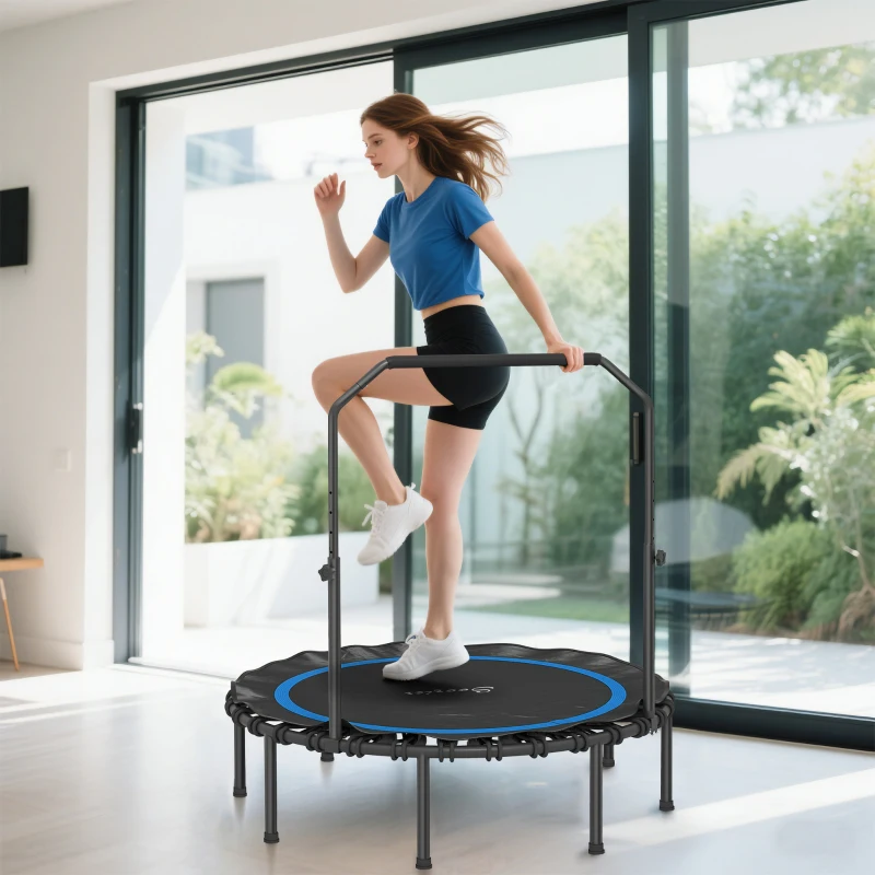 Woman exercising on indoor fitness trampoline with handlebar near large windows.