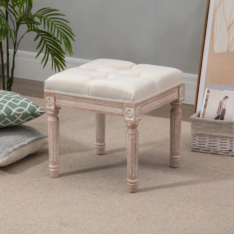 Small square tufted stool with carved wooden legs on carpet.

