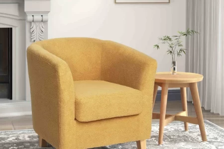 Vintage yellow tufted armchair with nailhead trim in cozy living room.