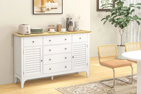 White sideboard with wooden top beside dining area and decor.