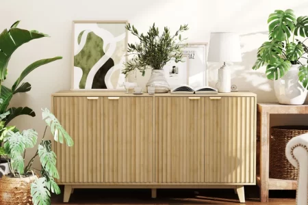 Wooden sideboard with décor accents and indoor plants in bright living room.