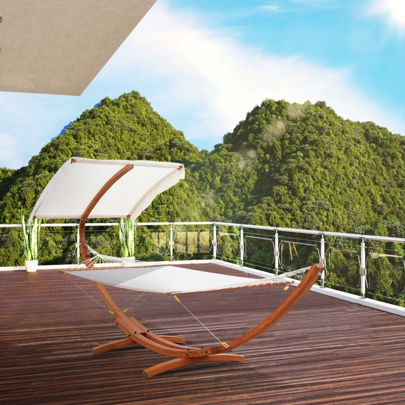 White canopy hammock on wooden stand overlooking green mountains.