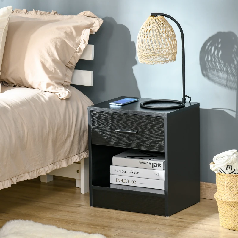 Modern black nightstand beside bed with lamp and books.