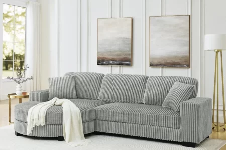 Grey corduroy sectional sofa with throw blanket in modern home.