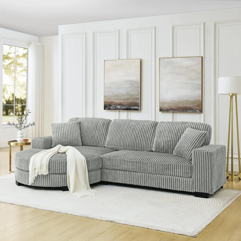 Grey corduroy sectional sofa with throw blanket in modern home.