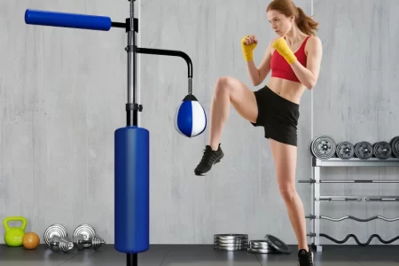 Woman practicing kickboxing with blue punching and reflex trainer.
