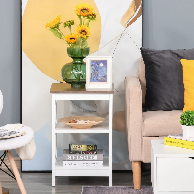 White side table with shelves and green vase beside sofa.