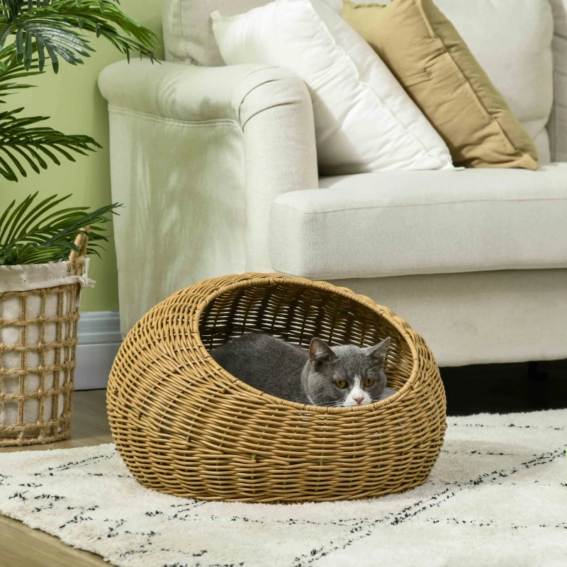 Gray cat sitting in a woven wicker basket pet bed.