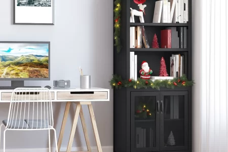 Black bookcase decorated with Christmas garland and ornaments in a home office.