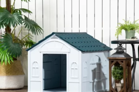 dog house placed outdoors on a wooden deck with plants and lanterns nearby.