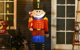 Large inflatable nutcracker holding candy cane outside festive house.