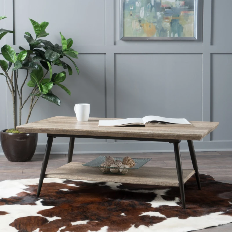 Mid-century coffee table with lower shelf on a cowhide rug.