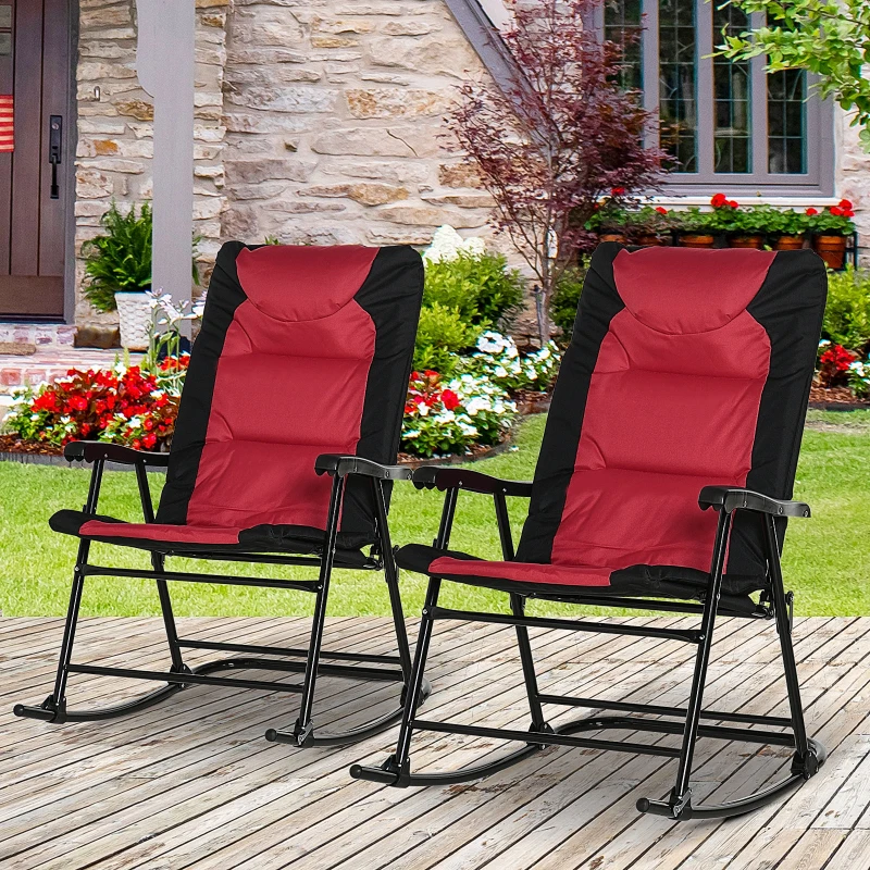 Two red and black folding rocking chairs placed on a wooden patio with garden view.