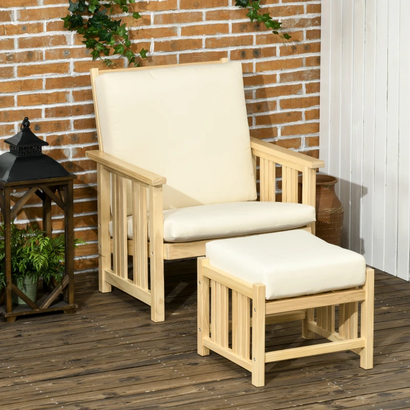 Wooden outdoor armchair with cream cushions and matching ottoman on deck beside brick wall.