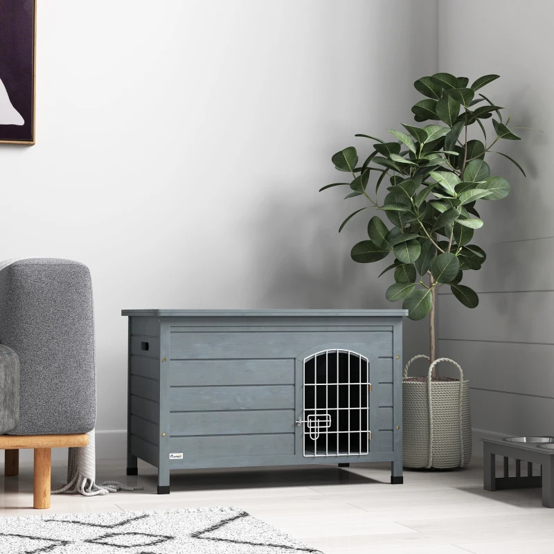 grey wooden indoor dog crate styled as furniture with a dog resting inside.