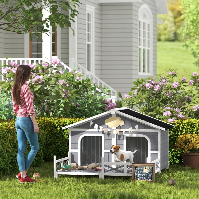 outdoor double dog house with porch featuring a small dog standing on the deck.