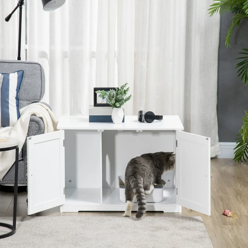 Cat using hidden litter box inside modern white cabinet.
