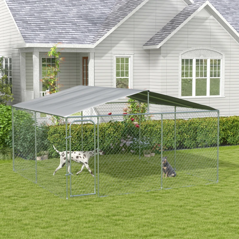 Two dogs inside a chain-link kennel with dual canopy roof in a residential backyard.