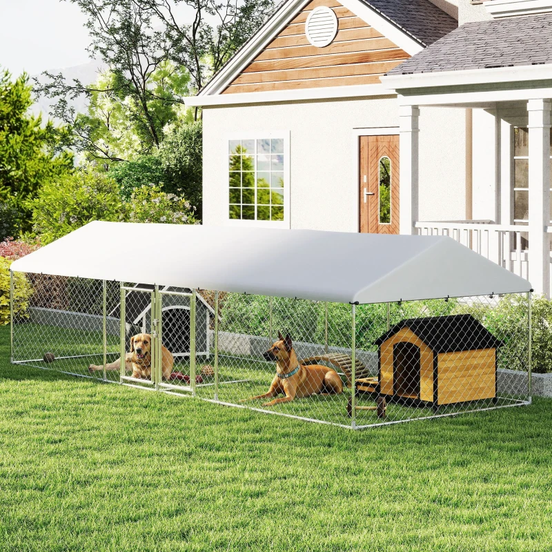 Two dogs resting inside a long chain-link kennel with a white canopy and wooden dog house.