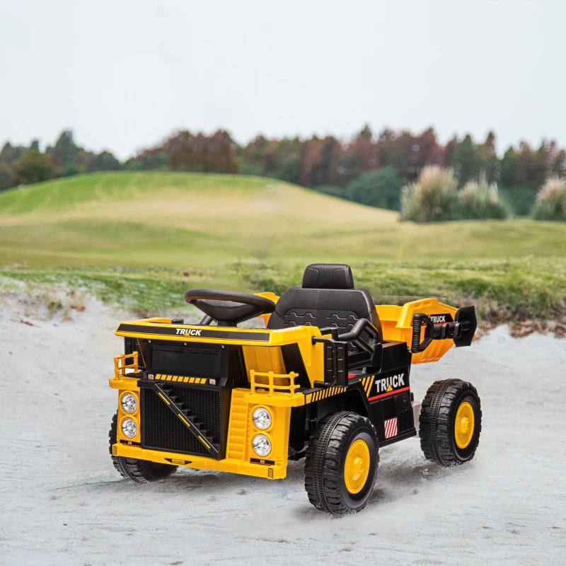 Yellow ride-on dump truck toy on sandy outdoor playground.