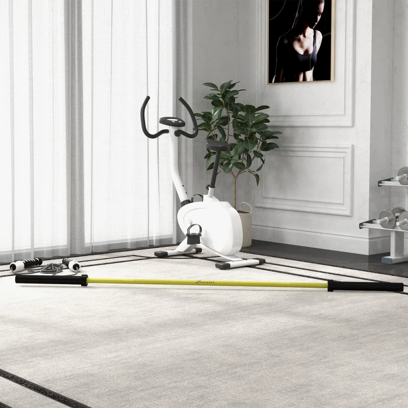 Yellow Olympic weight bar placed on home gym floor beside exercise bike.