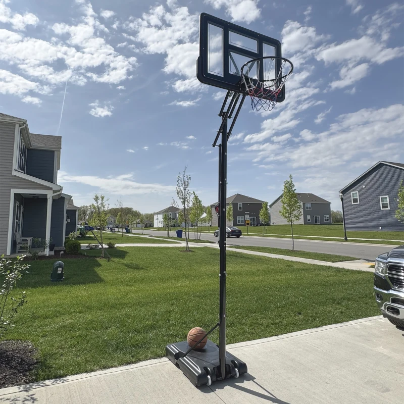 Adjustable freestanding basketball hoop set up on residential driveway.